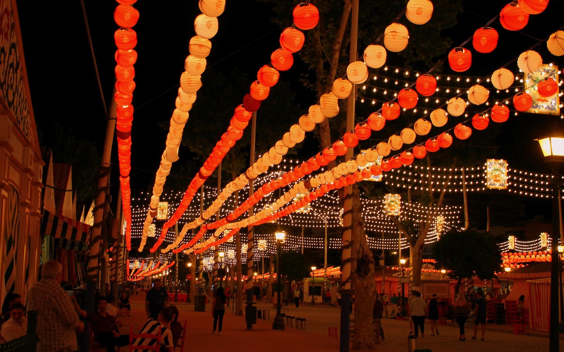 Lights strung over a Seville street, the look of the April fair at night