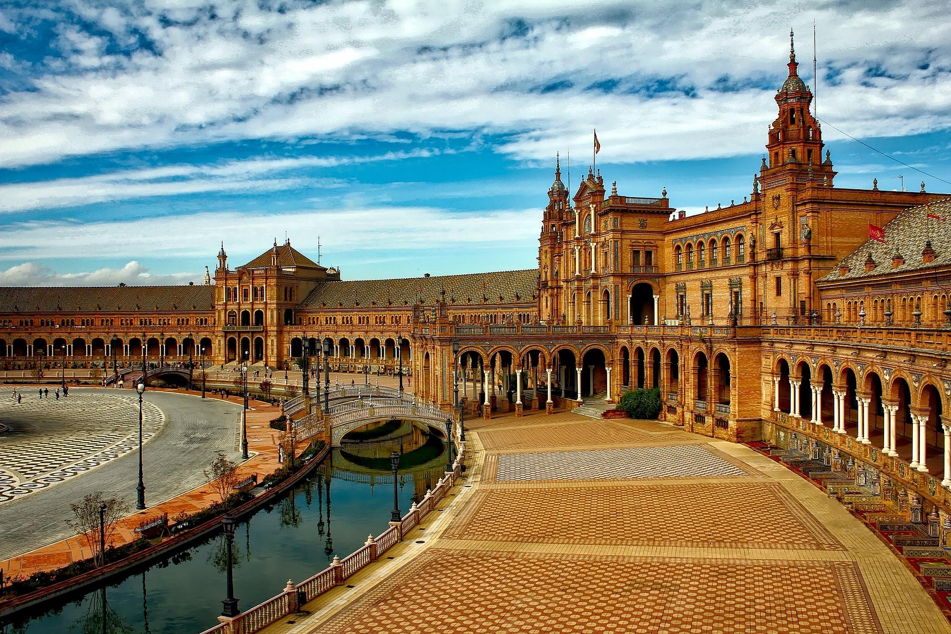 Travelers walking a historic Spanish plaza with a local guide